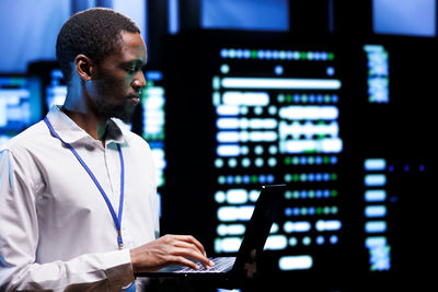 Side view of young man working at airport