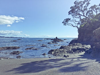 View of calm beach against blue sky