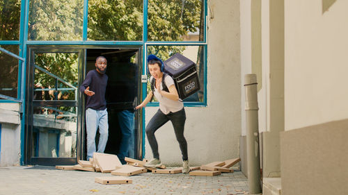 Rear view of young woman standing against building