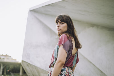 Portrait of young woman looking back over shoulder