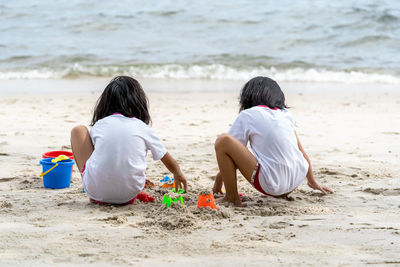 Rear view of children playing on beach