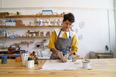 Happy ceramist girl in workshop studio prepare raw clay for shaping at classes. craftsmanship hobby