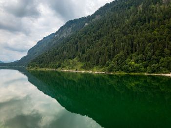 Scenic view of lake by mountains against sky