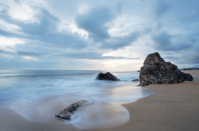 Rocks on beach against sky