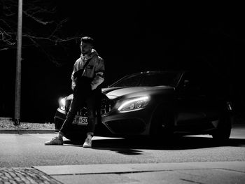 Man standing on street at night