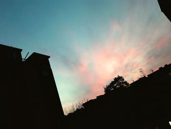 Low angle view of silhouette buildings against sky at sunset