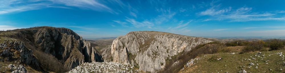 Panoramic view of landscape and mountains against blue sky