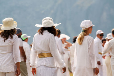 People wearing white clothes standing outdoors