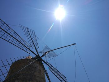 Low angle view of traditional windmill against clear blue sky on sunny day