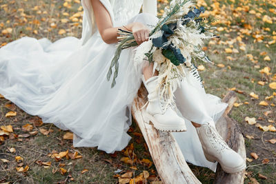 Midsection of bride holding bouquet