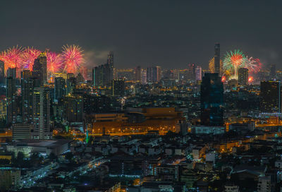 Illuminated cityscape against sky at night