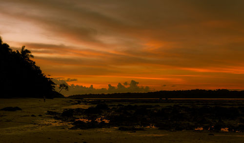 Scenic view of field against orange sky