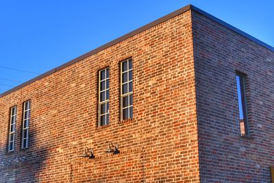 Low angle view of building against clear blue sky at sunset