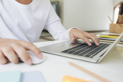 Midsection of man using laptop on table