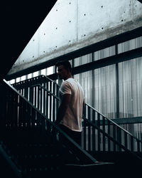 Rear view of man walking on staircase