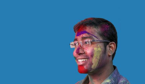 Portrait of man wearing mask against blue background