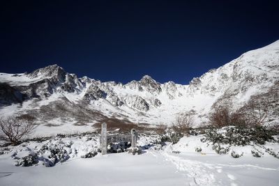 Snowcapped mountains against clear blue sky