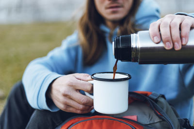 Man pouring coffee from insulated drink container