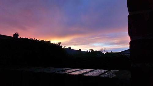 Silhouette buildings against sky during sunset