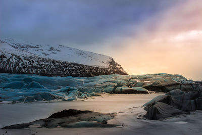 Scenic view of snow covered landscape against cloudy sky