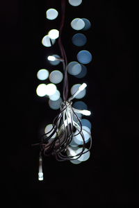 Close-up of illuminated light bulb against black background