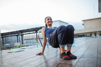 Low angle view of young woman standing in city