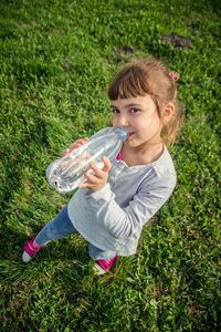 High angle view of woman drinking water bottle