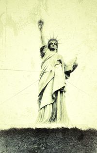 Statue of woman standing against wall