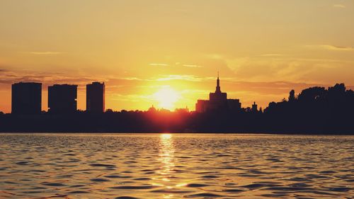 Silhouette of buildings against sky during sunset