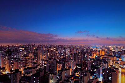 High angle view of illuminated buildings against sky at night