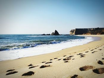 Scenic view of beach against clear sky