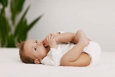 Portrait of cute baby lying on bed at home