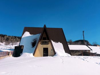 Houses against clear blue sky during winter