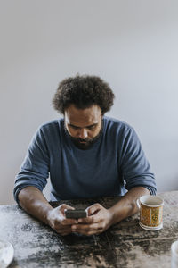 Man sitting at table and using phone