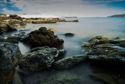 Rocks in sea against sky