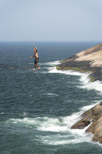 Man surfing in sea against sky