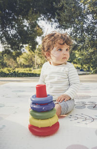 Cute boy looking away while sitting on table