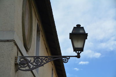 Low angle view of lamp on building against sky