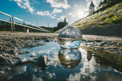 Close-up of crystal ball with reflection in water