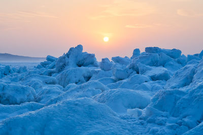 Scenic view of frozen sea against sky during sunset