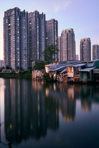 Reflection of buildings in city against sky