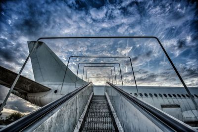 Low angle view of escalator against sky