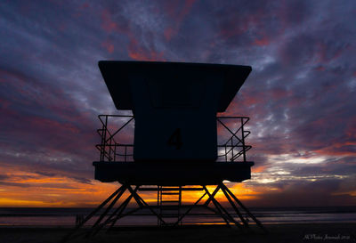 Low angle view of lifeguard hut against sky during sunset