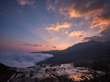 Scenic view of mountains against sky at sunset