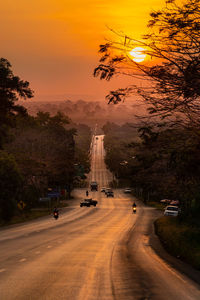 Cars moving on road at sunset