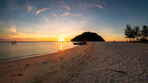 Scenic view of beach against sky during sunset