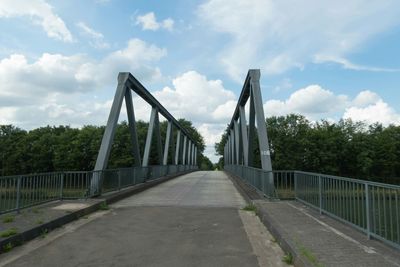 Bridge over river against cloudy sky