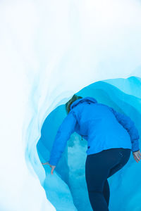 Rear view of woman walking in ice cave