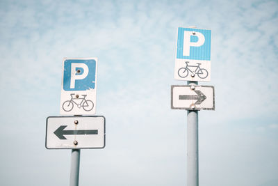 Low angle view of road signs against sky