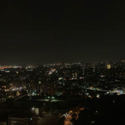 Illuminated cityscape against sky at night